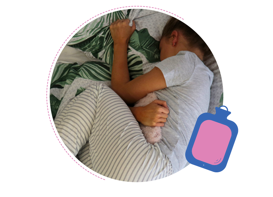A young person suffering from period pain using a hot water bottle